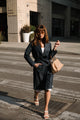 Woman in a dark coat walking on a city street