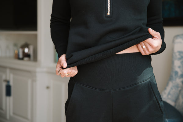 Person wearing a black outfit with a blurred indoor background