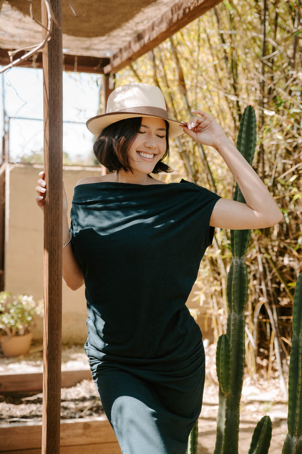 woman wearing long black dress with tan fedora