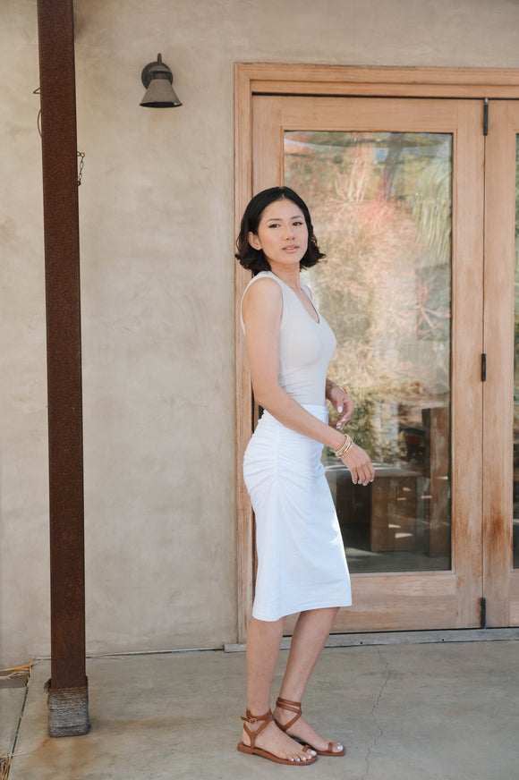 woman wearing tan tank top with long white skirt