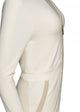 closeup of cream colored jumpsuit with gold zipper, from side angle