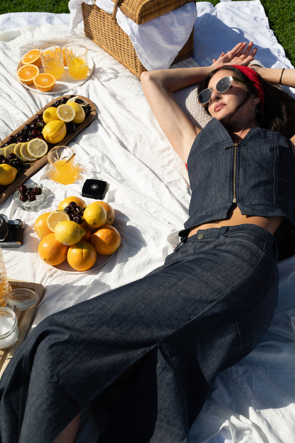 woman wearing denim vest with gold zipper, and denim skirt