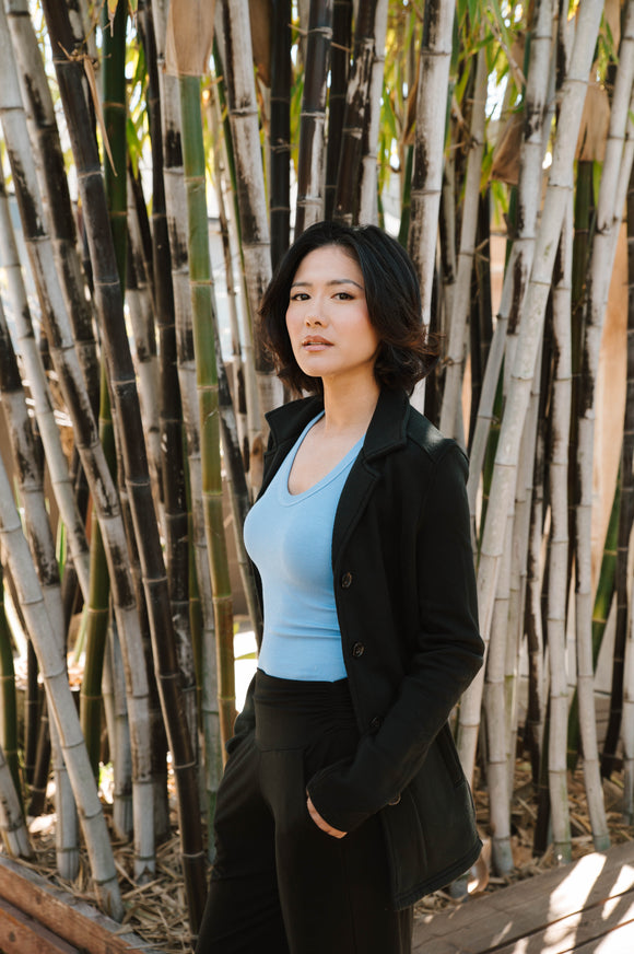 Woman standing in front of a bamboo fence