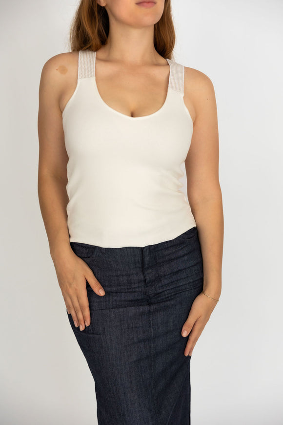 woman wearing a V-neck white tank top and jeans