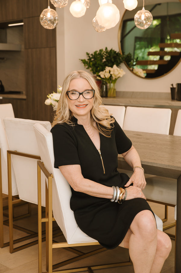 Woman sitting at a dining table in a stylish interior setting