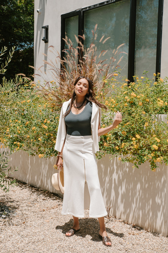 Woman standing outdoors with flowers and plants around her