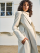 woman wearing long white overcoat
