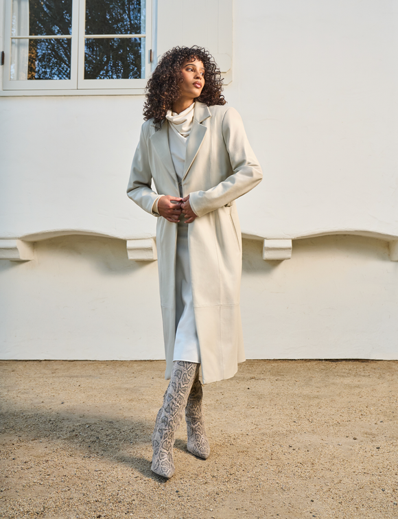 woman wearing long white dress with white overcoat