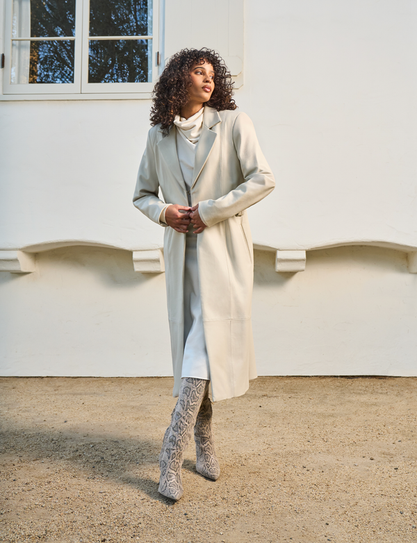 woman wearing long white dress with white overcoat