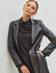 woman wearing long black dress with black leather overcoat,