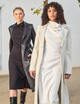 two women, one wearing long black dress with black leather overcoat, and the other wearing long white dress with white overcoat