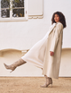 woman wearing long white dress, with white overcoat