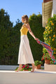 Woman wearing a long white skirt with yellow tank