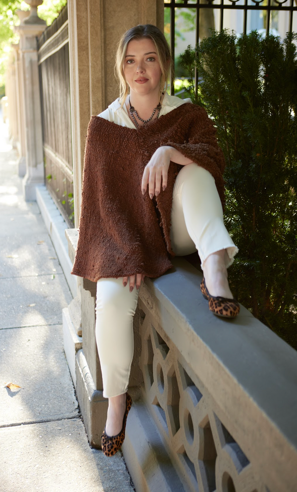 woman wearing tan shirt and tan pants, with brown covering