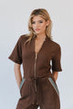 woman wearing brown shirt with gold zipper and brown pants