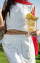 woman wearing white shirt and white pants, with gold chain around waist and red scarf