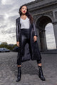 woman wearing black trench coat with a white shirt and leather pants