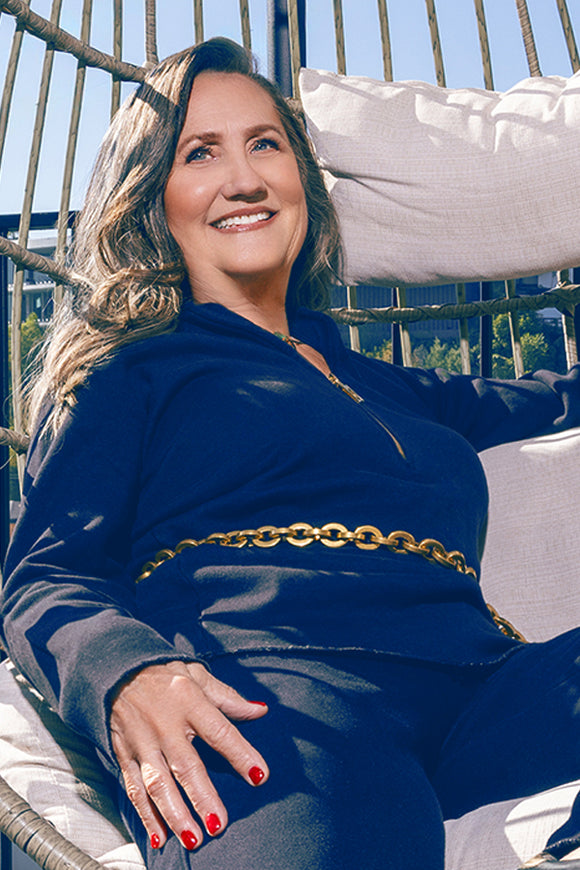 woman wearing a navy light quarte zip with gold zipper