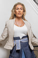 woman wearing white shirt, denim skirt with blue patterned inside, along with cream blazer
