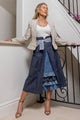woman wearing white shirt, denim skirt with blue patterned inside, along with cream blazer