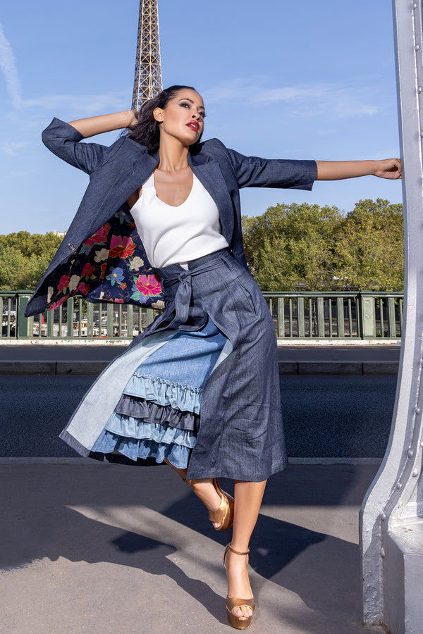 woman wearing white tank top, navy blue skirt with blue frilled designed inside of skirt, along with navy blue overcoat