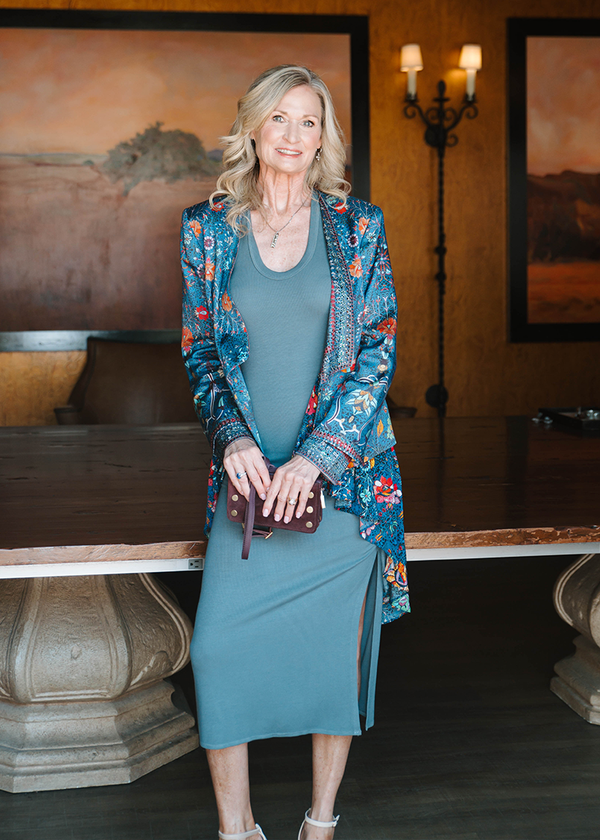 woman wearing sky blue shirt and sky blue skirt, and floral patterened overcoat