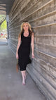 video of woman wearing long black dress with sunglasses and brown bag with gold chain