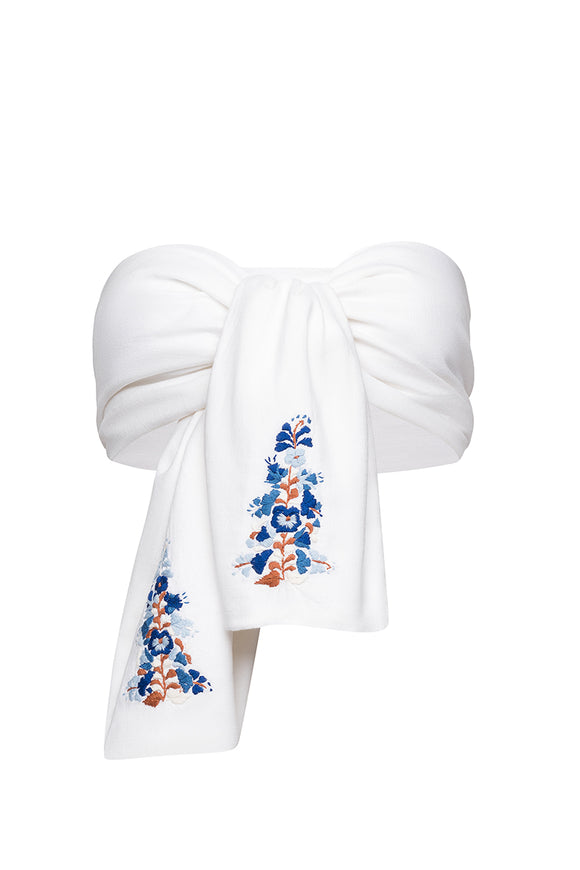 close up of floral pattern on white bow, with peach, blue, and light blue colors