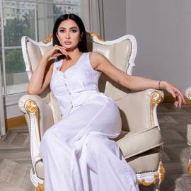 Woman in a all white outfit sitting in a white chair