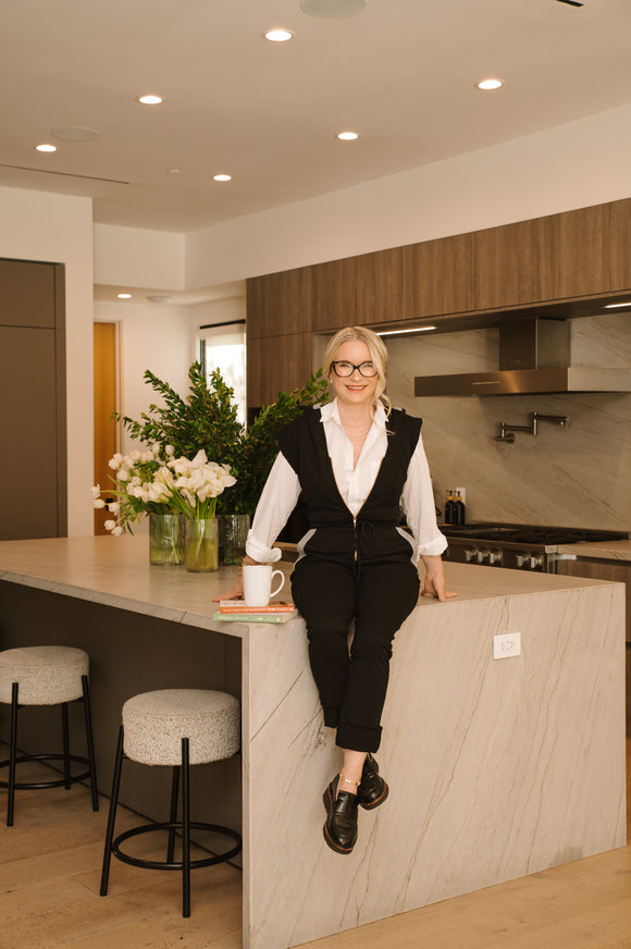 Woman sitting on a kitchen counter with a modern kitchen in the background